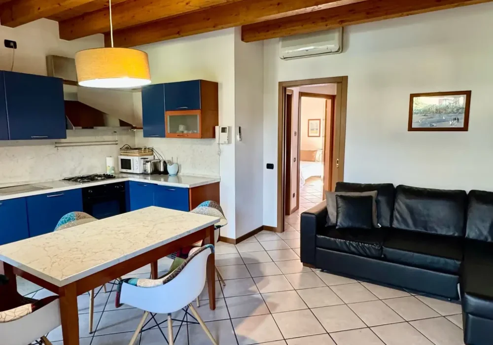 Soggiorno moderno con cucina, tavolo da pranzo e divano.